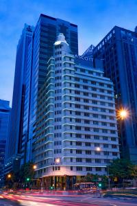 a large building in a city at night at Ascott Raffles Place Singapore in Singapore