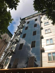 a building with a reflection of the sky in the windows at Hotel Azumaya Linh Lang in Hanoi