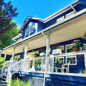 een blauw huis met potplanten op de veranda bij Seafarer Bed & Breakfast in Tofino