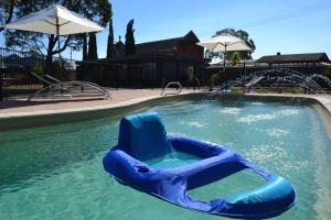 a blue raft in the water in a swimming pool at Wingham Motel in Wingham