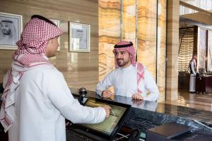 a woman talking to a man behind a counter at Boudl Al Sahafa in Riyadh +34 photos