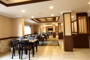 a dining room with tables and chairs in it at Prayana Hotels in Cochin