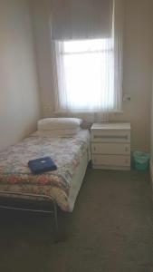 a small bedroom with a bed and a window at Orbost Club Hotel in Orbost