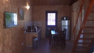 una pequeña cocina con mesa y nevera en Villa saisonnière chez dédé, en Saint-Joseph