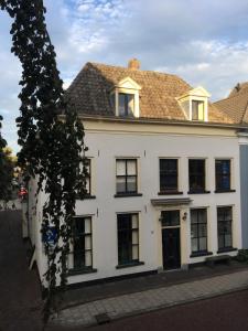 a white building with black windows and a roof at B&B Het Rode Hert in Doesburg