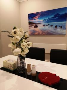 un vaso con fiori bianchi seduto su un tavolo di Home Sweet Home a Oamaru
