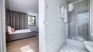 a bathroom with a shower and a bed in a room at Hotel Reich Winterbach in Winterbach +46 photos