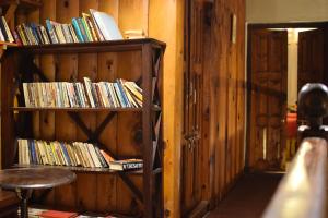 a room with a book shelf filled with books at Fredy's Bungalow near Nainital in Bhīm Tāl