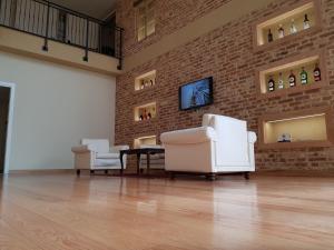 two white chairs and a table in a room with a brick wall at Cascina Speranza Hotel in Riva presso Chieri