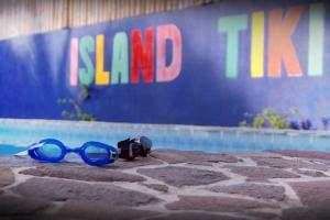 parę niebieskich okularów przeciwsłonecznych siedzących obok basenu w obiekcie Island Tiki Paradise Resort w Panglao City