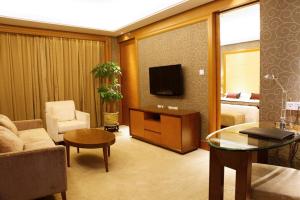 
a living room filled with furniture and a tv at Geosciences International Conference Centre Hotel in Beijing
