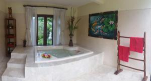 d'une baignoire dans une pièce ornée d'une peinture murale. dans l'établissement Toyabali Resort, Dive & Relax, à Tulamben