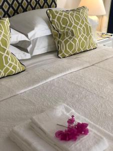 ein weißes Bett mit einer rosa Blume drauf in der Unterkunft Theotoki Liston Suite in Korfu-Stadt
