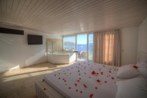 a bedroom with a bed with red flowers on it at Nur Hotel in Kaş +37 photos