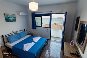 um quarto com uma cama azul e vista para o oceano em Riva Del Mare em Archangelos