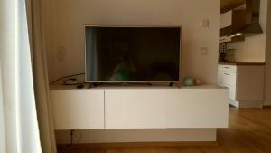 a flat screen tv sitting on top of a white cabinet at Ferienwohnung TREIBGUT in Uhldingen-Mühlhofen