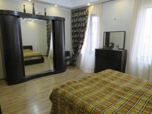 een slaapkamer met een bed en een grote spiegel bij вилла in Tbilisi City