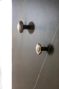 a pair of door knobs on a wall at MaisonMe Boutique Hotel in Bardolino