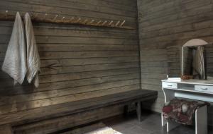 a wooden bathroom with a bench and a sink at Olkka ranch in Mustakulkkula +25 photos