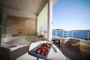 a room with a tub and a glass of wine at Nur Hotel in Kaş