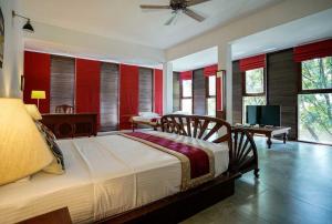 a bedroom with a large bed with red walls at Atelier in Kandy