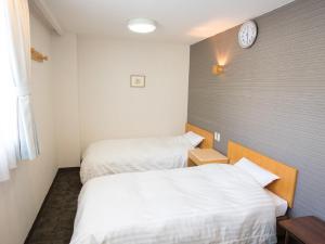 Ένα ή περισσότερα κρεβάτια σε δωμάτιο στο Itoen Hotel Iizakakanouya