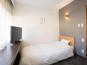 Ένα ή περισσότερα κρεβάτια σε δωμάτιο στο Itoen Hotel Iizakakanouya