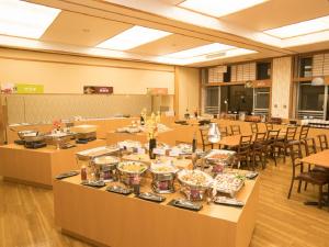 a large room with tables and chairs with food at Itoen Hotel Iizakakanouya in Fukushima