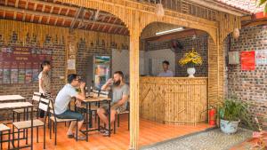 ニンビンにあるTam Coc Riverside Homestayのレストランの席に座る男たち