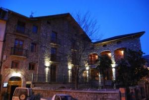 a large stone building with lights in front of it at L'Alcova Turisme Rural in Montardit