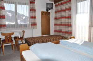 a bedroom with two beds and a table and chairs at Pension Mannharthof in Westendorf