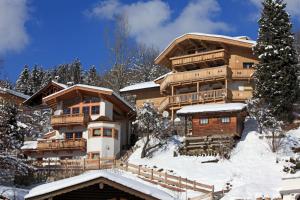 ein großes Blockhaus mit Schnee auf dem Boden in der Unterkunft Haus Schönblick in Kirchberg in Tirol