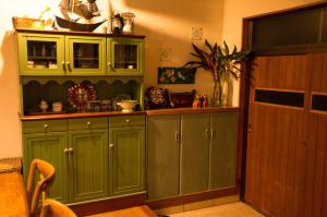 a kitchen with green cabinets and a counter at Guest House Amakara Okinawa in Nago