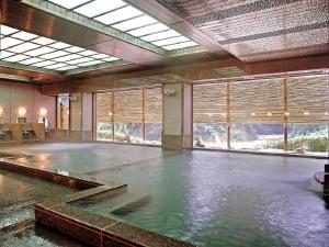 a pool of water in a large room with windows at Itoen Hotel Iizakakanouya in Fukushima