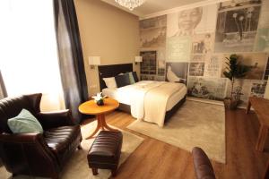 WeißenseeにあるHotel Promenadenhofのベッドとテーブルと椅子のあるホテルの部屋
