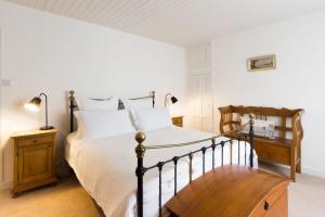 a bedroom with a large bed with white pillows at Picturesque Seaside Cottage Next to Viking Bay - Broadstairs in Broadstairs