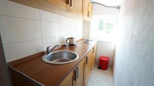 a small kitchen with a sink and a window at Guest House Sandra in Tisno
