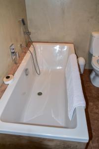 uma banheira branca na casa de banho com WC em Birchwood A & B @ Clarens em Clarens
