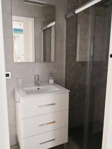 a bathroom with a white sink and a shower at Apartamentos en Paseo Maritimo in El Rompido +37 photos