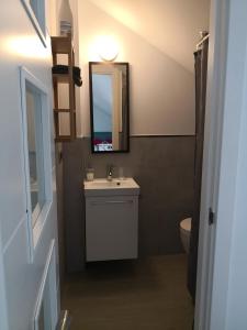 a bathroom with a sink and a mirror and a toilet at Apartamentos en Paseo Maritimo in El Rompido