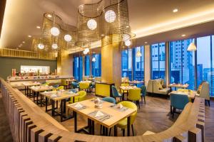 a restaurant with tables and chairs and windows at Ascott Central Wuxi in Wuxi