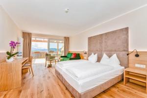 una camera d'albergo con un grande letto e una scrivania di Hotel Regina a Soprabolzano