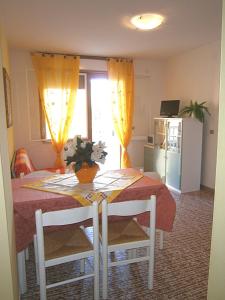 ビビオーネにあるElbaのテーブル付きの部屋、黄色いカーテン付きのキッチンが備わる客室です。