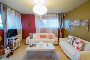 a living room with two white couches and a table at Dream Catcher Artemis in Artemida