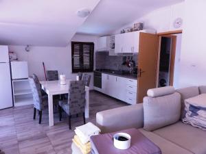 een woonkamer en een keuken met een bank en een tafel bij Apartment Tonka in Zaton