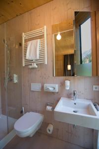 a bathroom with a sink and a toilet and a mirror at Alpenhotel Ammerwald in Reutte