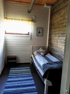 a small bedroom with a bed and a window at Olkka ranch in Mustakulkkula