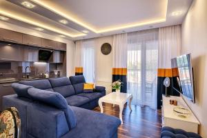 salon z niebieską kanapą i kuchnią w obiekcie About Art Apartments - Sikorskiego we Wrocławiu