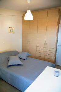 1 dormitorio con 1 cama grande y armarios de madera en Catherine's Comfort Apartment Νο3 en Lávrion