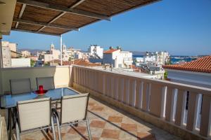 a balcony with a table and chairs and a view of the city at Catherine's Comfort Apartment Νο3 in Lávrion